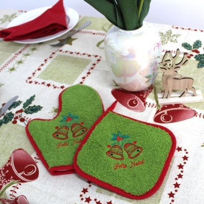 Jogo de cozinha verde e vermelho com sinos e texto Feliz Natal, em mesa com toalha natalícia