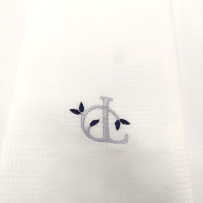 Toalha branca com bordado de letras e folha