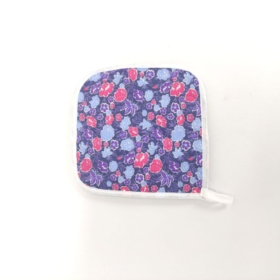 Pano de cozinha quadrado com padrão floral em azul, roxo e vermelho com texto LEGACY YVERDON.