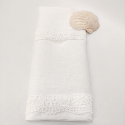 Guardanapo branco com renda e concha sobre fundo branco