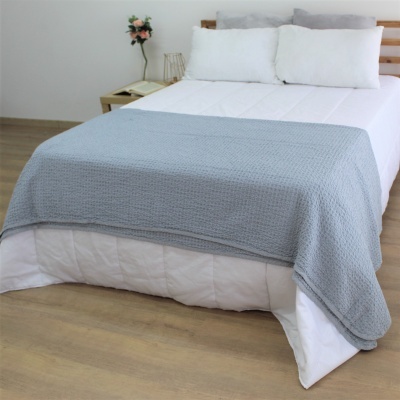 cama com colcha cinza clara texturizada sobre edredão branco