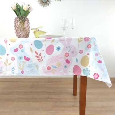 Toalha de mesa com padrão colorido de ovos e flores sobre mesa de madeira