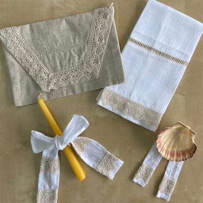 Conjunto de artigos têxteis com renda, vela amarela e concha