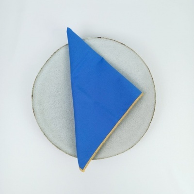 Prato redondo cinzento com guardanapo azul dobrado no centro