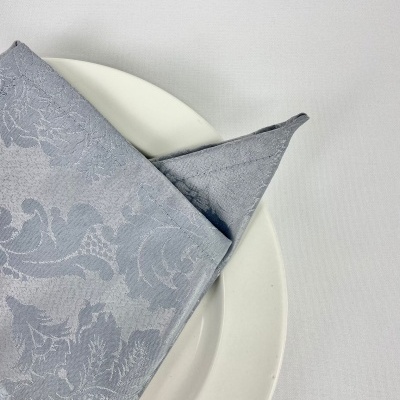 Guardanapo cinzento com padrão floral sobre prato branco