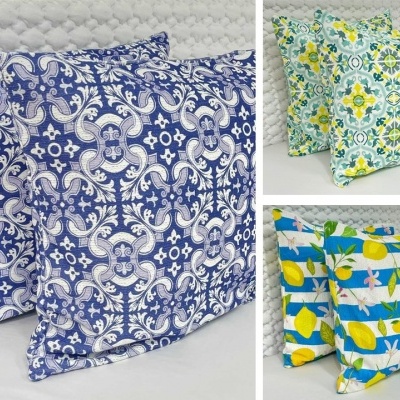 Três conjuntos de almofadas com padrões florais e geométricos em azul, amarelo e verde.