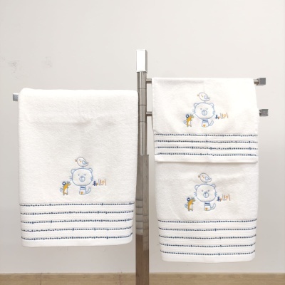 Toalhas brancas de algodão com bordados azuis de ursinho e animais, penduradas em suporte metálico
