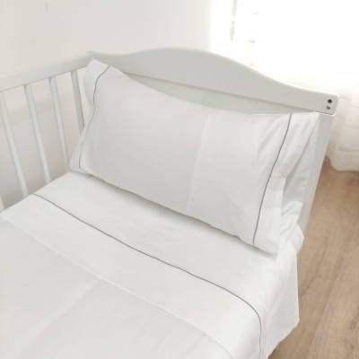 Berço branco com roupa de cama branca com costura cinza fina