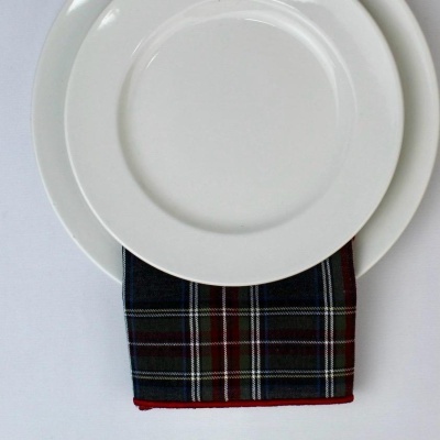 Dois pratos brancos com guardanapo de padrão tartan entre eles