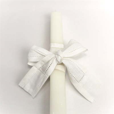 Vela branca com fita de tecido branca atada a laço