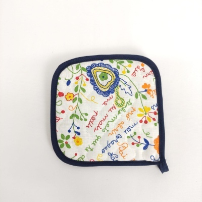 Luva ou pega de cozinha branca com padrão floral e texto colorido