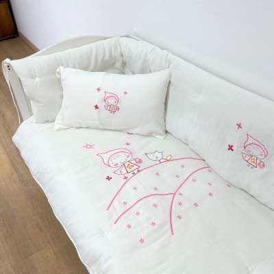 Conjunto branco de almofadas e colcha com bordados rosa de personagens infantis