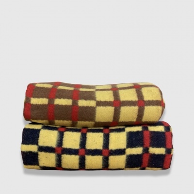 Duas mantas dobradas com padrão xadrez em cores castanho e amarelo, azul e amarelo.