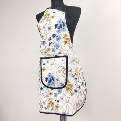 Avental floral azul e amarelo em manequim preto