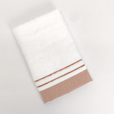 Toalha branca com riscas castanhas e barra castanha