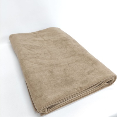 Toalha bege clara dobrada sobre superfície branca