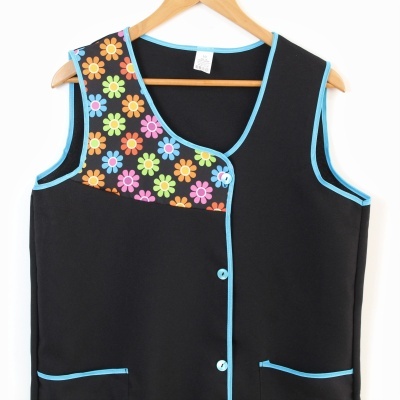Colete feminino preto com bordas azuis e detalhe floral colorido na parte superior esquerda