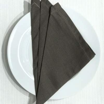 Guardanapo cinzento em prato branco sobre fundo branco