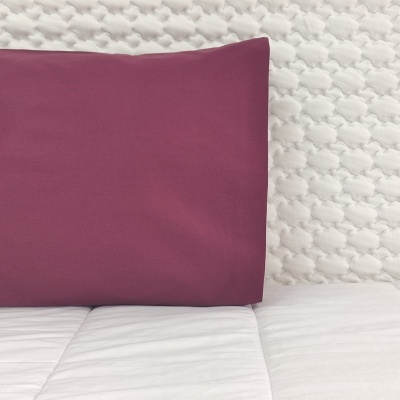 Almofada roxa numa superfície branca com padrão texturado