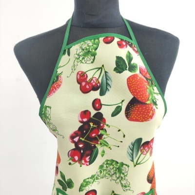Avental com padrão de frutas e bordas verdes num manequim preto