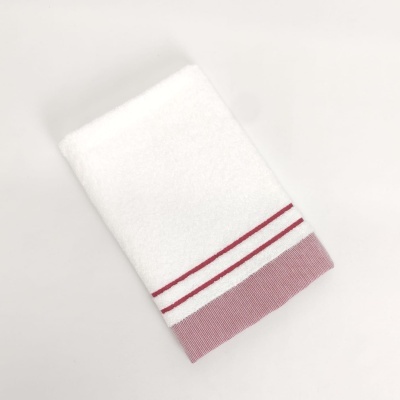 Toalha branca com borda rosa e riscas vermelhas