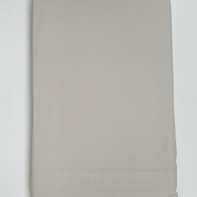 Lençol bege claro dobrado sobre fundo branco