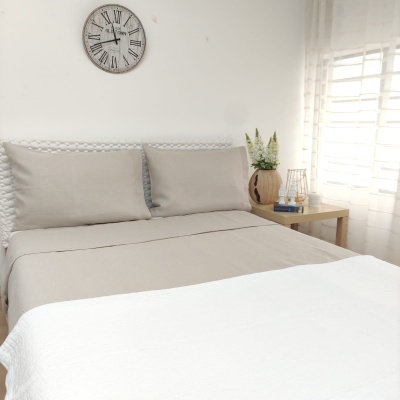 Quarto com cama de madeira branca e roupa de cama cinza e branca