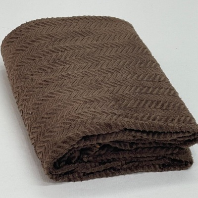 Manta dobrada castanha com padrão zig-zag em relevo