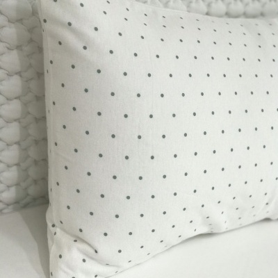 Almofada branca com pequenos pontos cinzentos