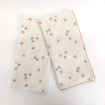 Dois panos de cozinha brancos com padrão castanho de pequenos insetos