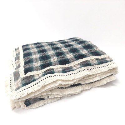 Manta dobrada com padrão xadrez e detalhes em crochê nas bordas