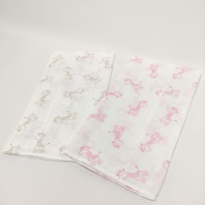 Dois panos de tecido branco com padrões de girafas bege e rosa