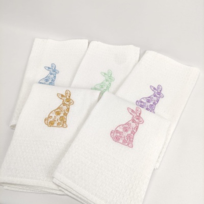 Toalhas brancas com bordados de coelhos coloridos