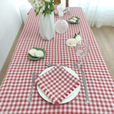 Mesa posta com toalha e guardanapo xadrez vermelho e branco e decoração com flores brancas