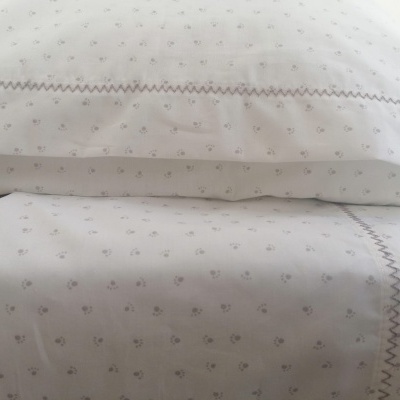 Jogo de cama branco com padrão floral e linha zig-zag cinzenta