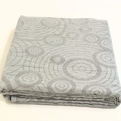 Colcha cinzenta dobrada com padrão de círculos concêntricos