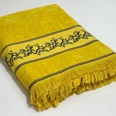 Toalha amarelo mostarda com franjas e padrão decorativo preto