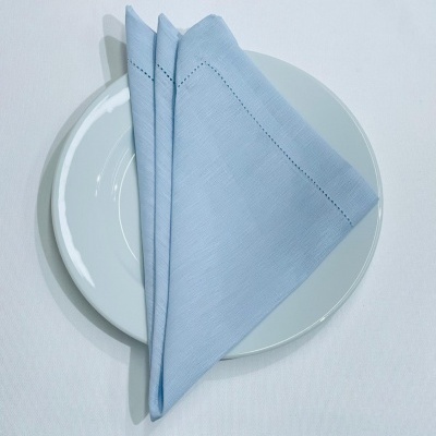 Guardanapo azul claro sobre prato branco