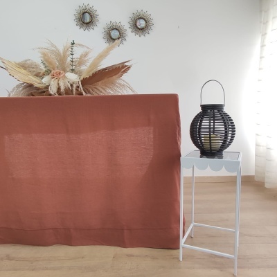 Sofá castanho com mesa branca e lanterna preta num ambiente luminoso com decoração natural e espelhos dourados