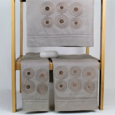 Conjunto de toalhas bege com padrão circular em estrutura de madeira