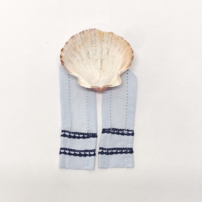 meias azuis claras com detalhes azul escuro e concha marinha sobre fundo branco