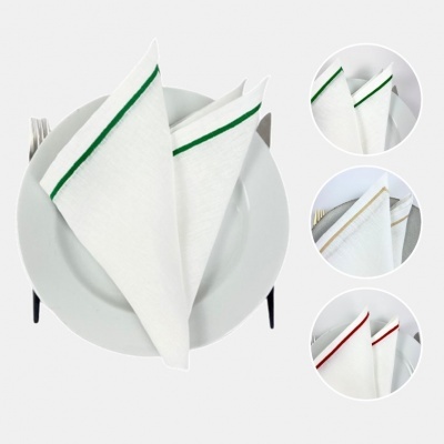 Guardanapos de tecido branco com bordas coloridas em prato branco