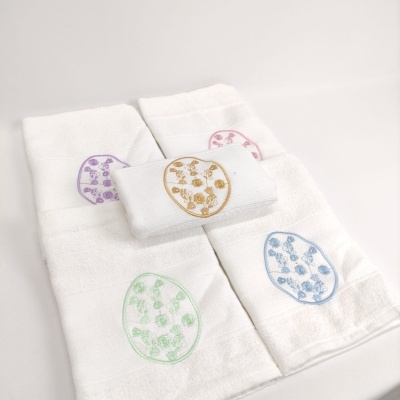 Toalhas brancas com bordados florais coloridos em ovals