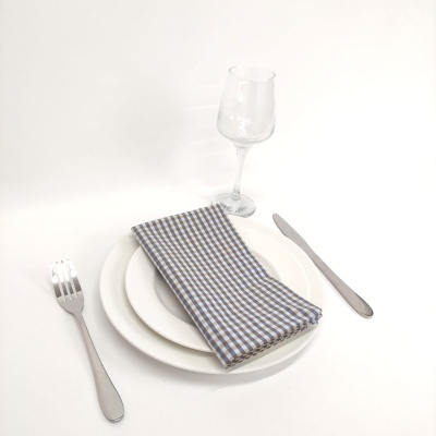 Conjunto de pratos, guardanapo, copo de vinho e talheres sobre fundo branco