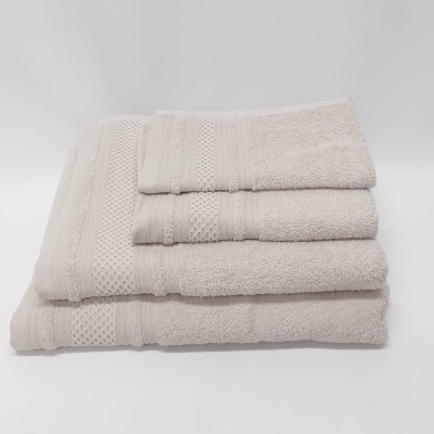 Conjunto de toalhas bege empilhadas com padrões tecidos