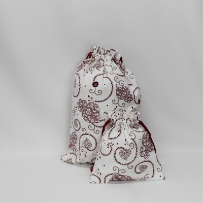 Dois sacos de tecido brancos com padrão bordô, fundos cinza claro