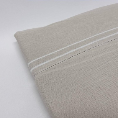 tecido bege com linhas brancas e detalhe ajour