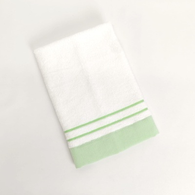 Toalha branca com riscas verdes na extremidade