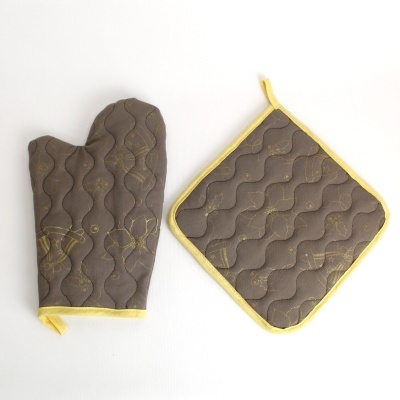 luva de forno e pega de tecido castanho com acabamento amarelo