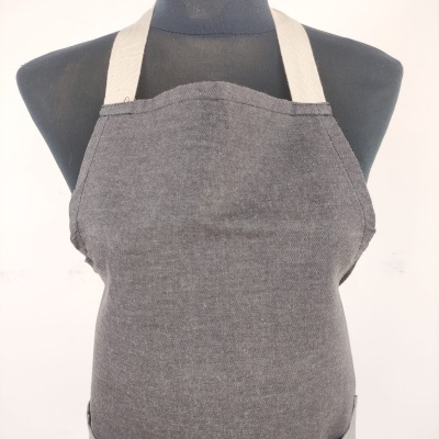 Avental cinzento com alças bege num manequim preto